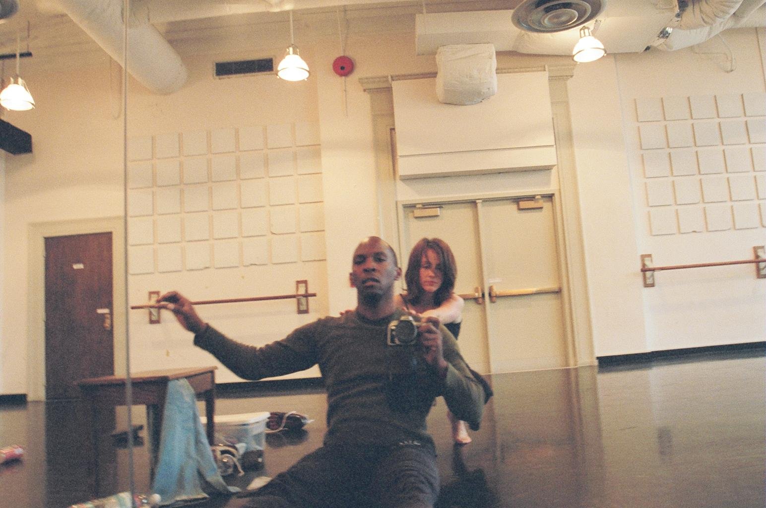 Boris Willis holding a camera in a dance studio mirror with a collaborator