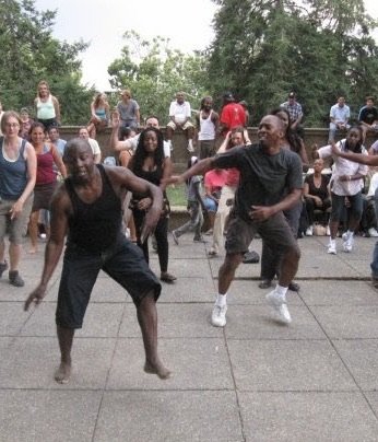 Boris Willis dancing outdoors with a group in a park