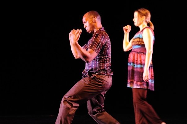 Boris Willis in a low stance with hands clasped, Cynthia McLaughlin behind