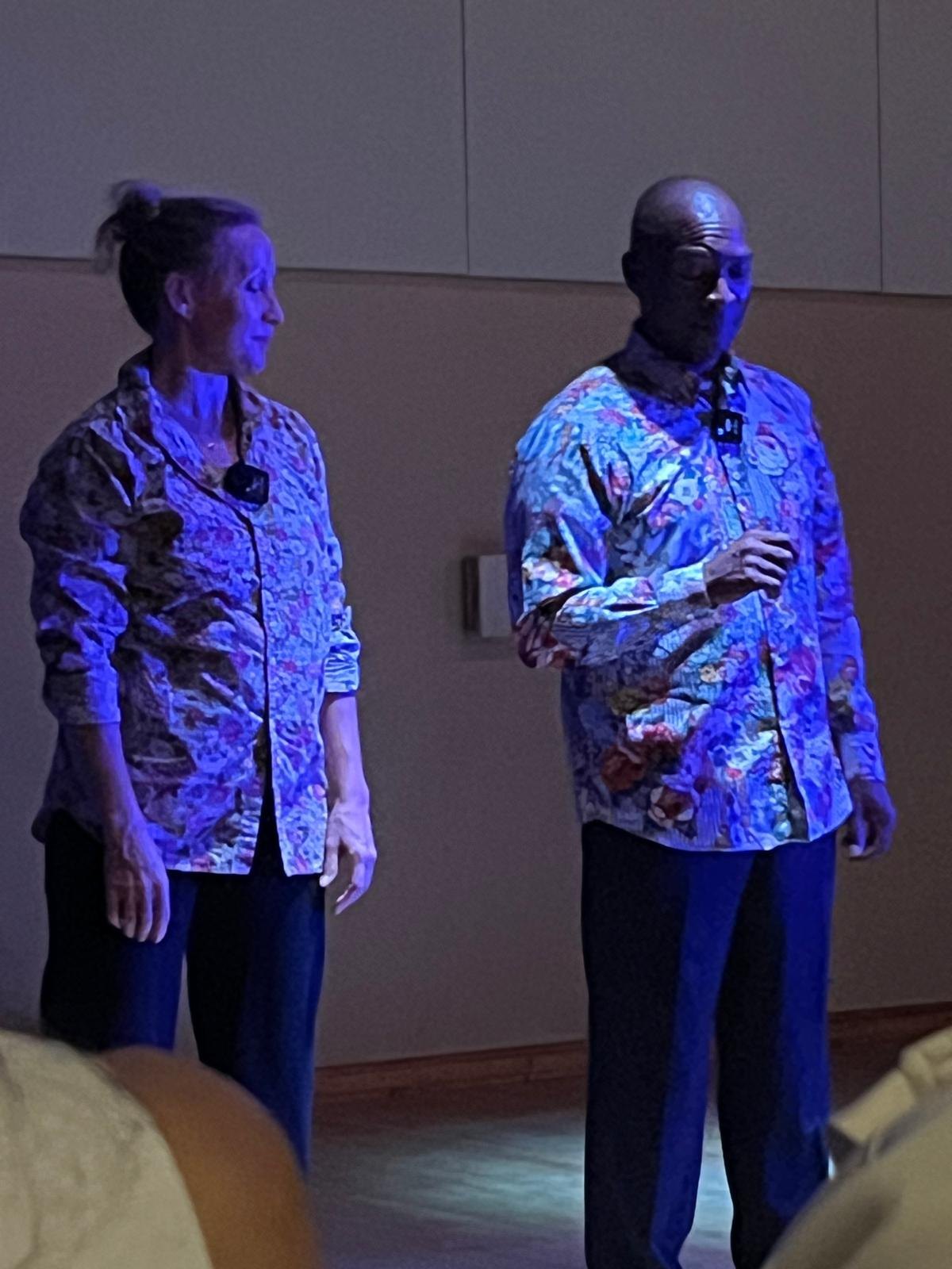 Keira Hart and Boris Willis a few steps apart under violet light