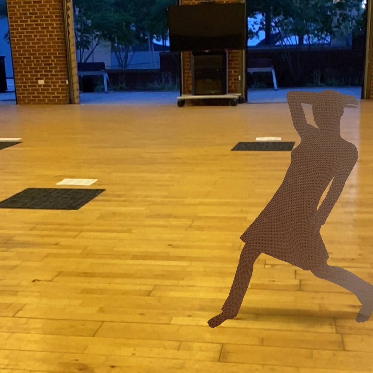 An augmented-reality figure mid-leap composited into the wooden-floored studio at dusk