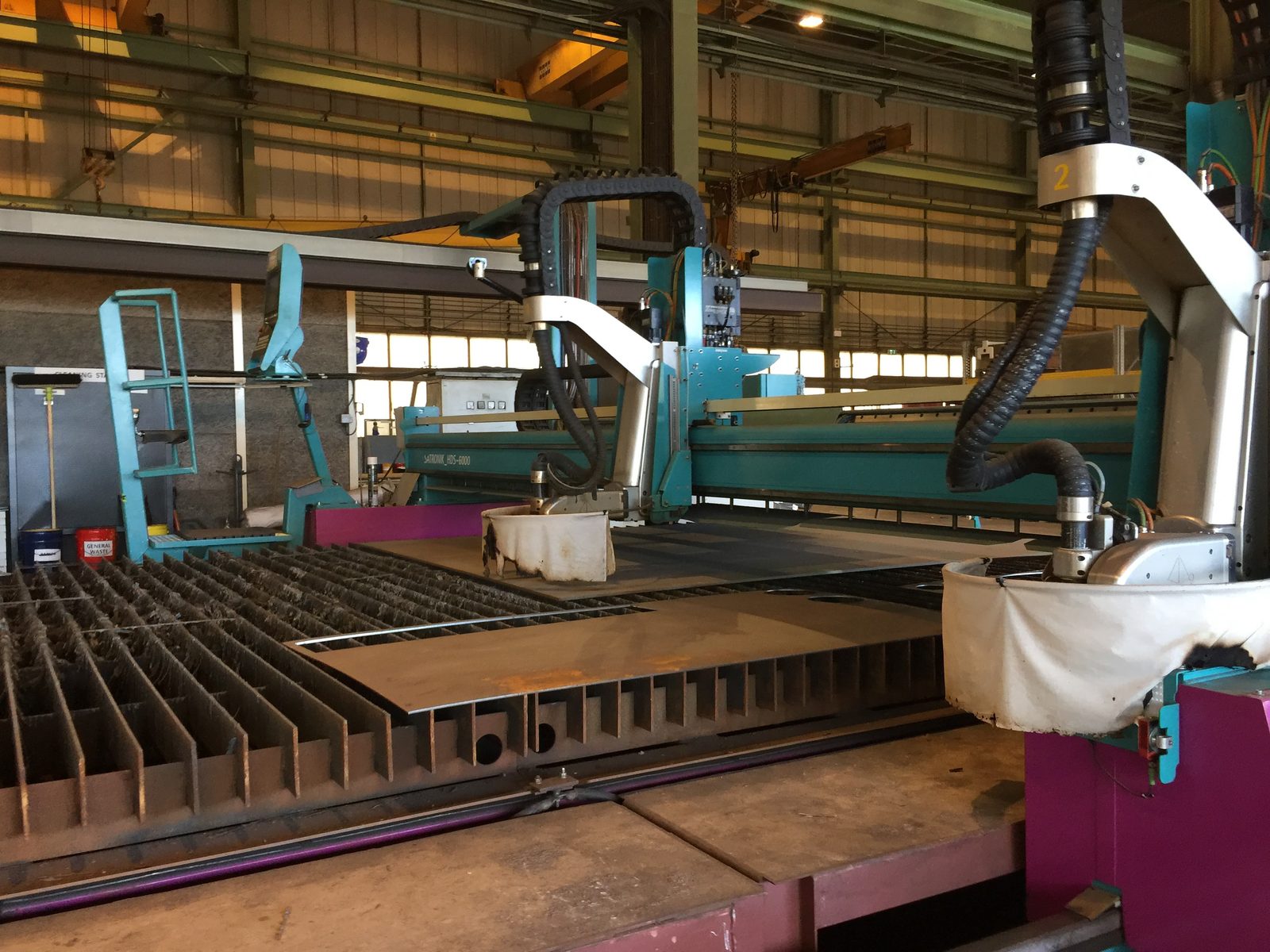 Industrial plasma-cutting machinery on the shipyard floor