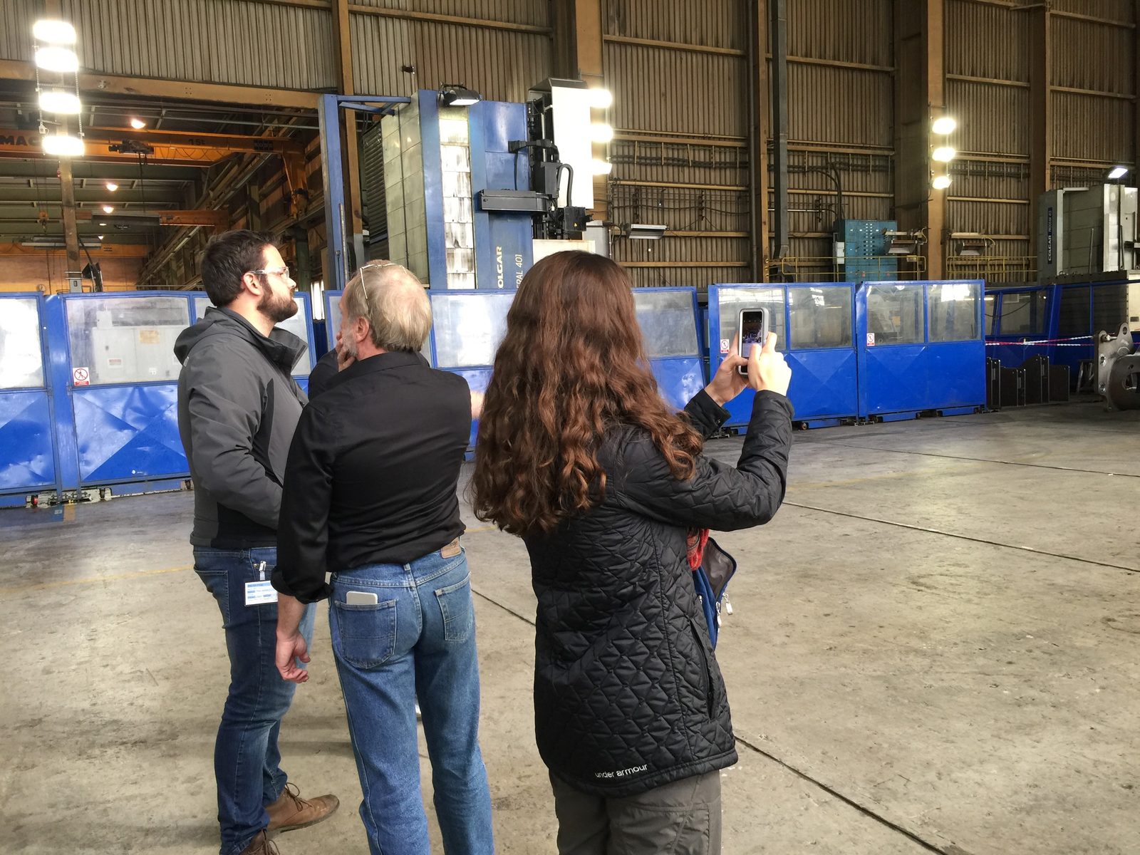 Three people scouting a location inside the factory hall