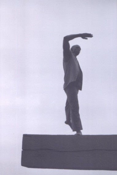 Boris Willis reaching upward on a waterfront platform