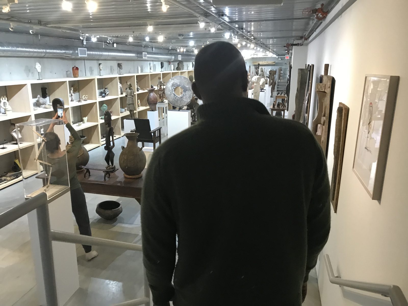 A figure silhouetted against the bookshelves of the Watermill Center library